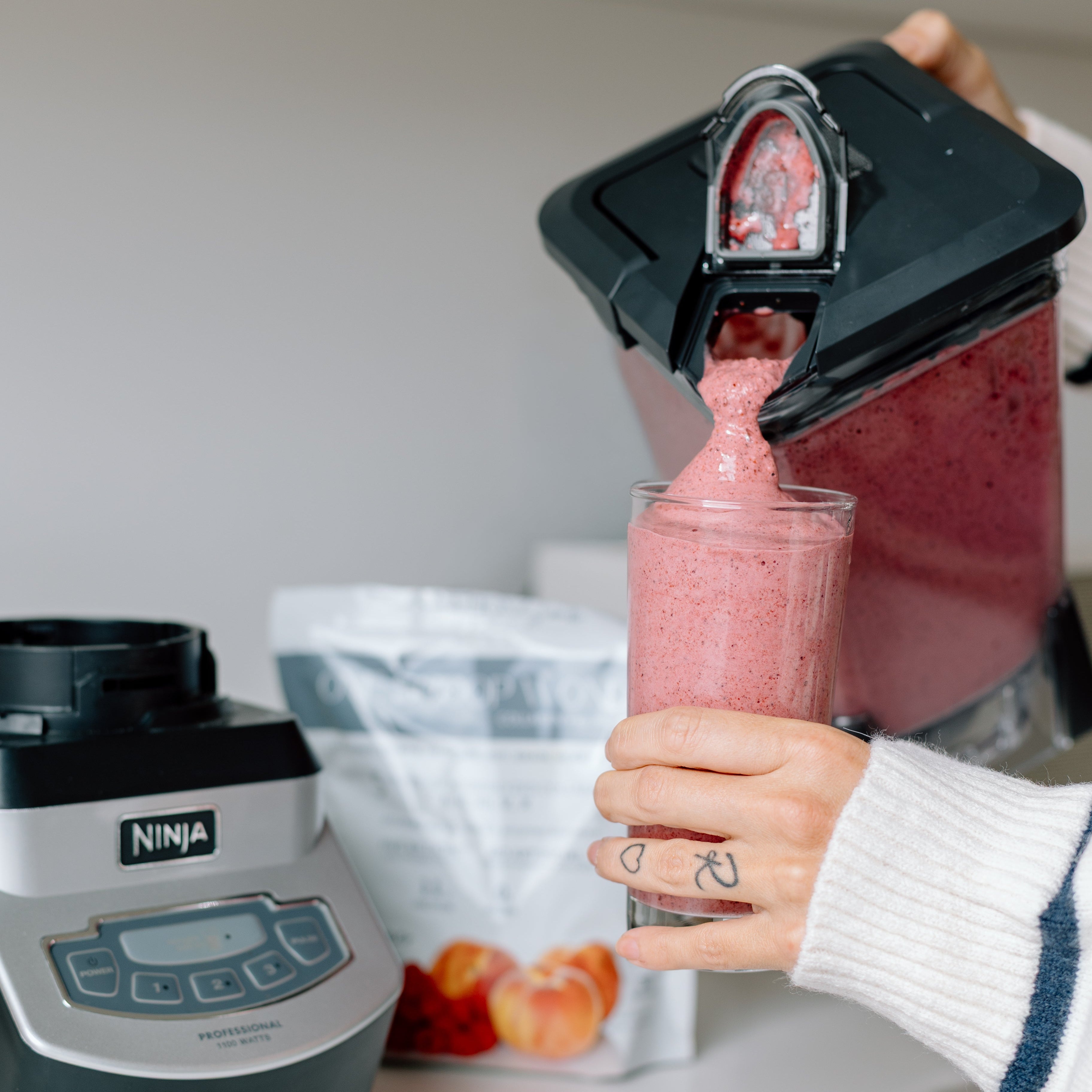 Pouring a One Scoop Wonder smoothie from blender into a glass.