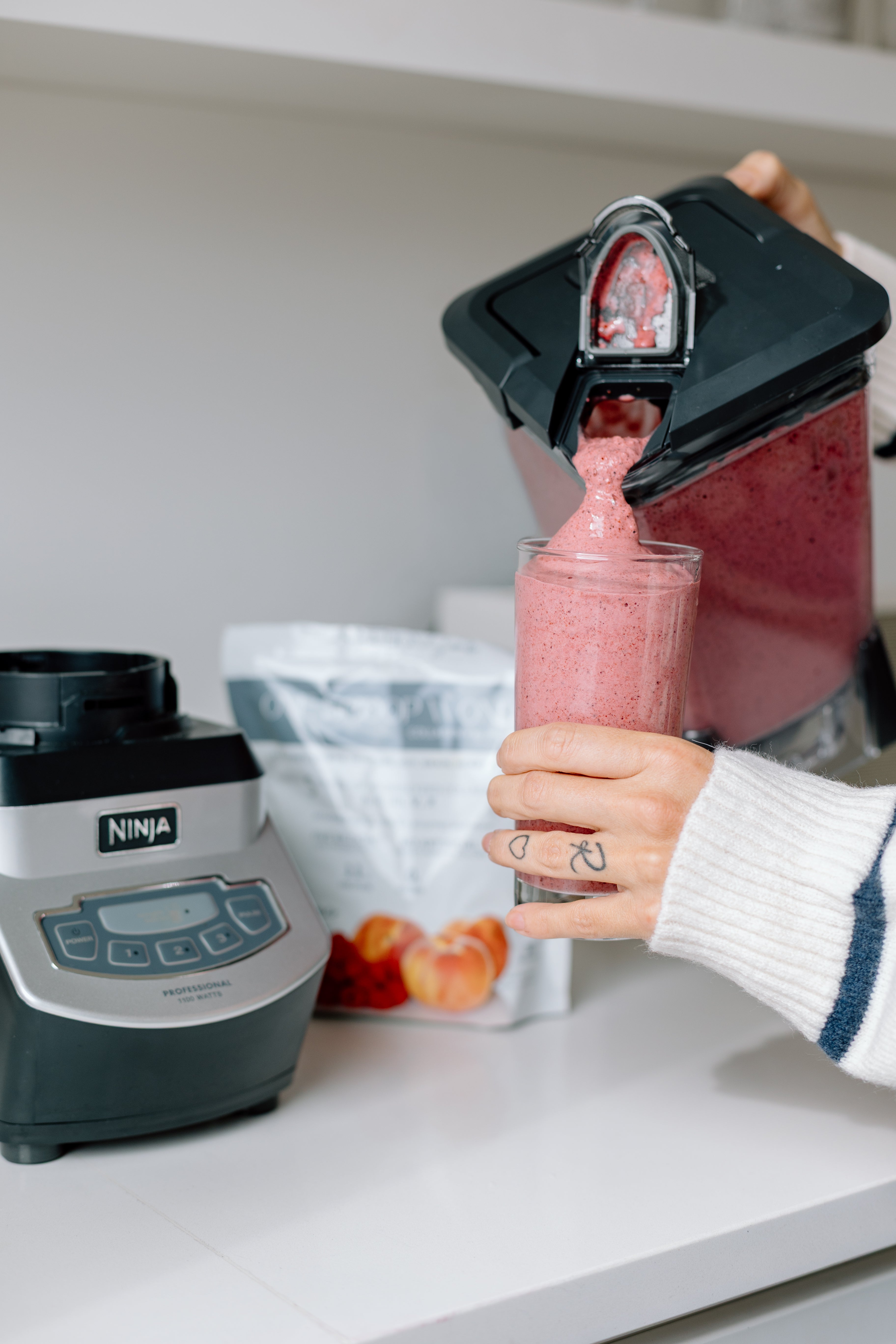Pouring a One Scoop Wonder smoothie from blender into a glass.